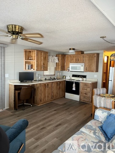 A kitchen with a desk and a couch.