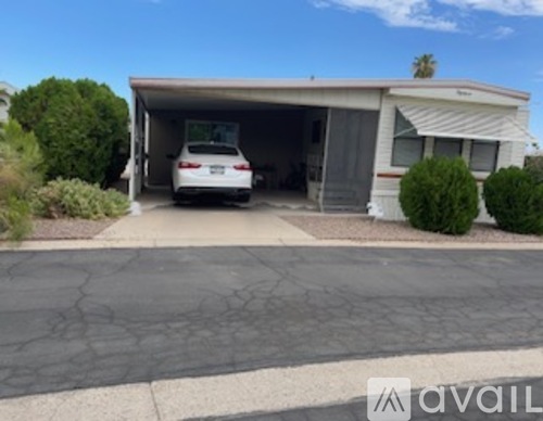 A car is parked in a garage attached to a house.