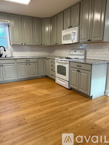 A kitchen with wooden floors and white appliances.
