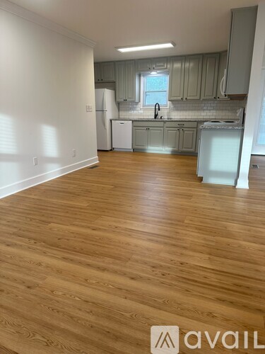 A kitchen with wooden floors and white appliances.