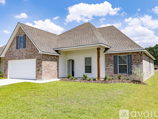 A house with a white garage door and a brown roof.