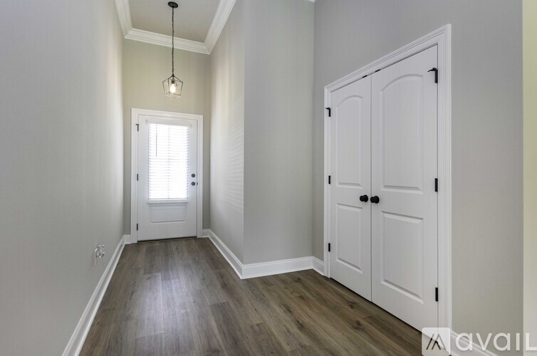 A room with a white door and a wooden floor.