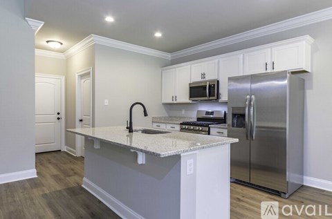 A kitchen with white cabinets and a granite countertop.
