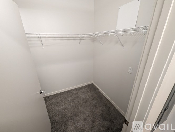 A small, empty room with a carpeted floor and a white wall.