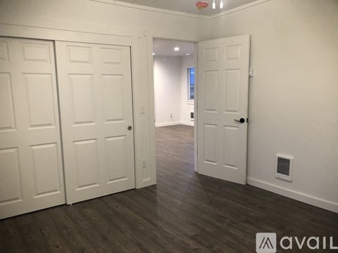 A hallway with two doors on either side and a third door at the end.