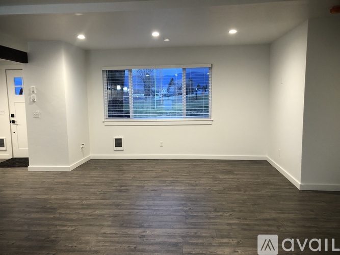 A room with a window and wooden flooring is available for rent.