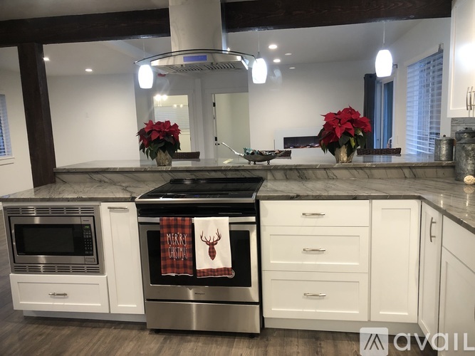 A kitchen with white cabinets and a marble countertop.