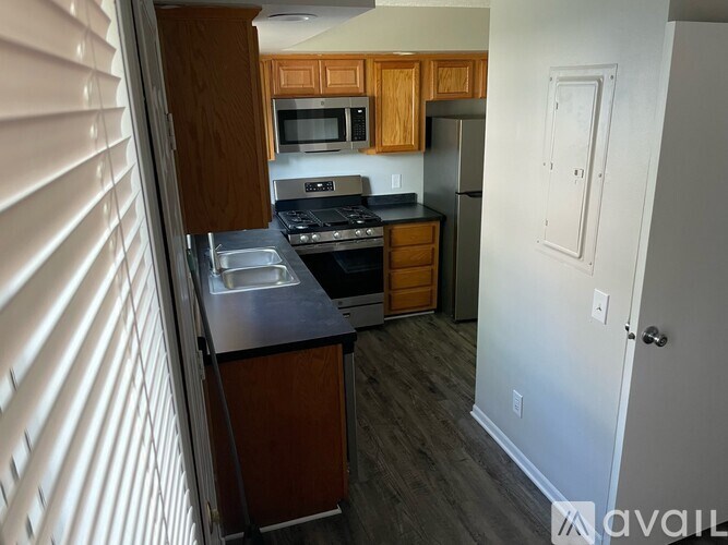 A kitchen with wooden cabinets and a black countertop.