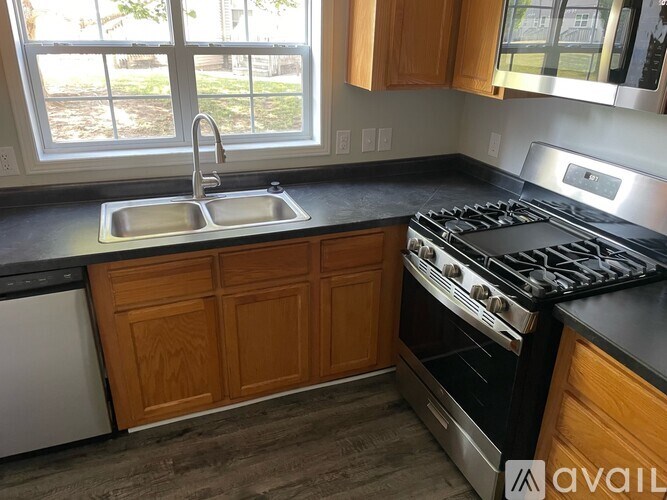A kitchen with a stove top oven and a double sink.