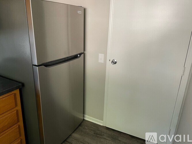 A stainless steel refrigerator in a kitchen corner.
