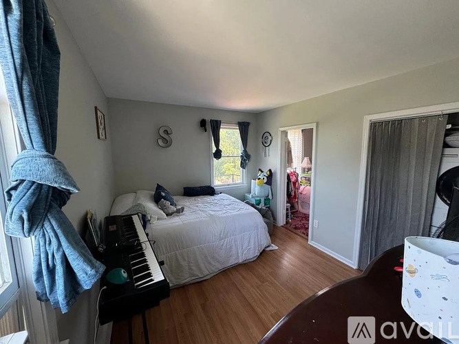 A room with wooden floors and two windows.