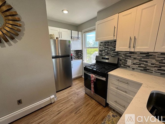 A kitchen with a stainless steel refrigerator and a black stove top oven.
