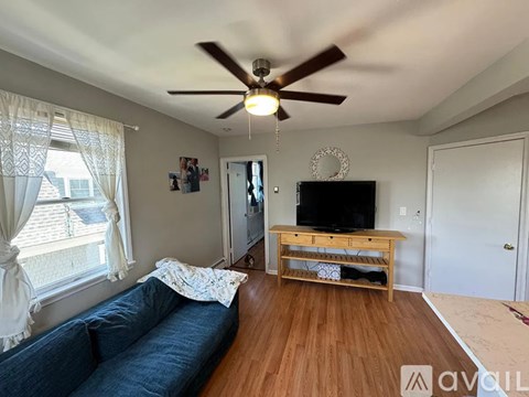 A living room with a blue couch and a wooden entertainment center.