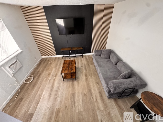 Two beds in a room with wood flooring and white walls.