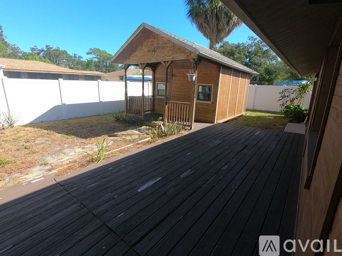 A wooden deck leads to a small wooden building with a porch.