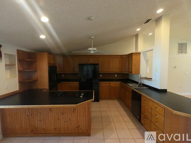 A kitchen with wooden cabinets and black countertops.