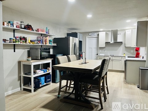 A kitchen with a table and chairs in the middle of the room.