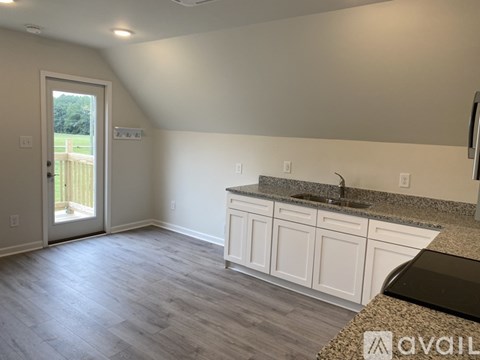 A kitchen with white cabinets and a granite countertop.