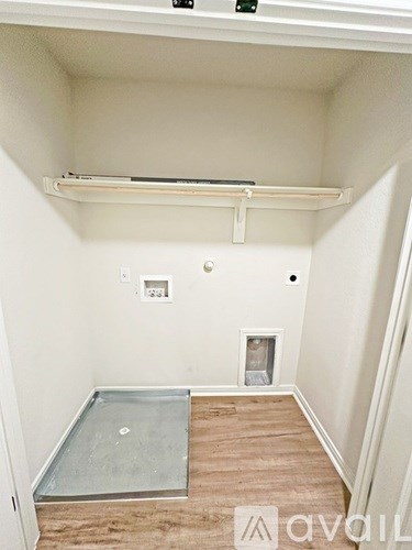 A room with a white wall and a wooden floor.