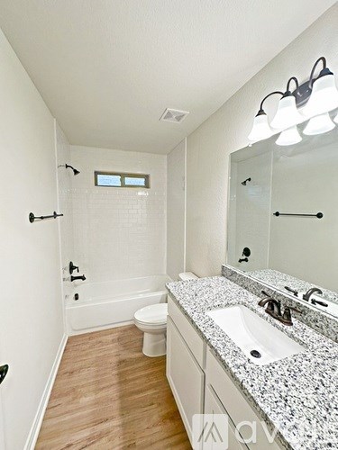 A bathroom with a toilet, sink, and mirror.