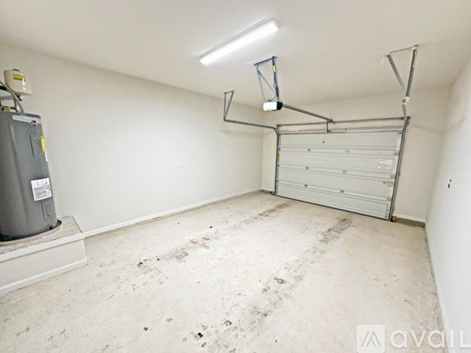 A white room with a garage door opener hanging from the ceiling.