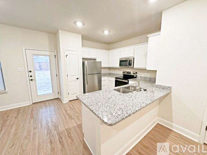 A kitchen with a granite countertop and stainless steel appliances.