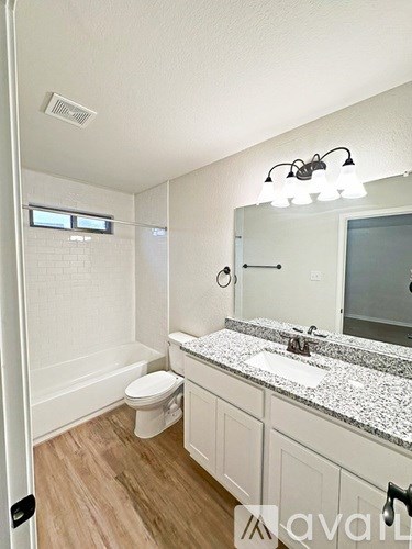 A bathroom with a toilet, sink, and mirror.