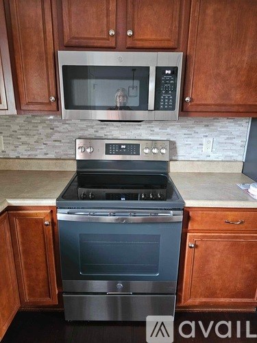 A kitchen with a stove and microwave.