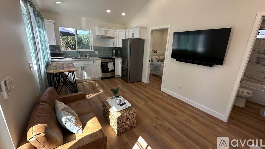 A living room with a brown leather couch and a wooden coffee table.