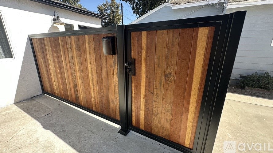 A wooden gate with a black frame is closed.