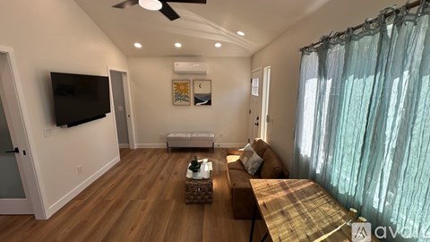A living room with a flat screen TV mounted on the wall.
