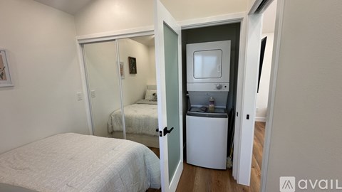 A bedroom with a bed, a fridge, and a microwave.