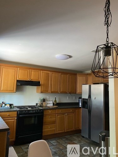 A kitchen with wooden cabinets and a black stove top oven.