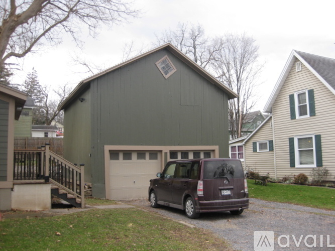 A garage with a brown car parked in front.