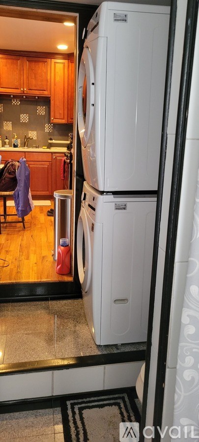 A white refrigerator is in a kitchen with wooden cabinets.