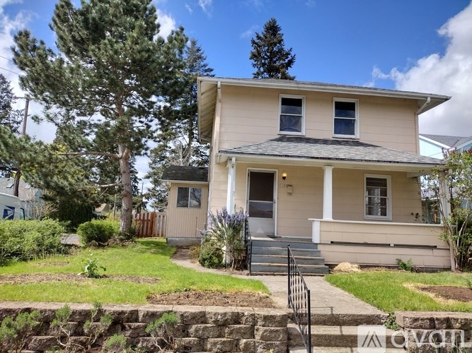 A two-story house with a front porch and a small front yard.