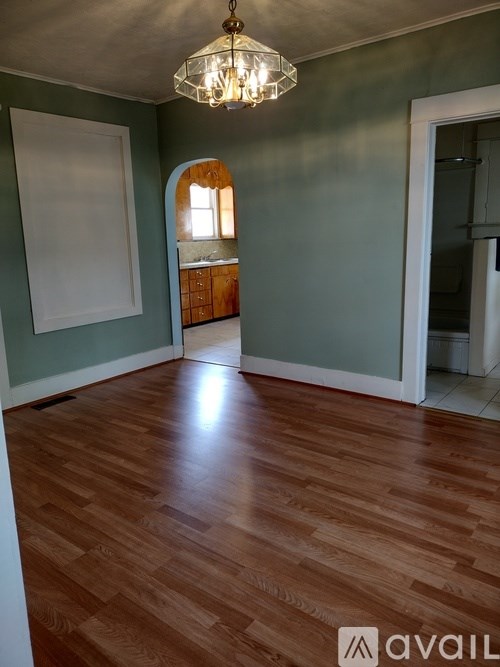 A room with wooden floors and a chandelier.