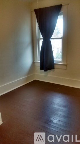 A room with a window and a curtain.