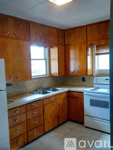 A kitchen with wooden cabinets and a white refrigerator.