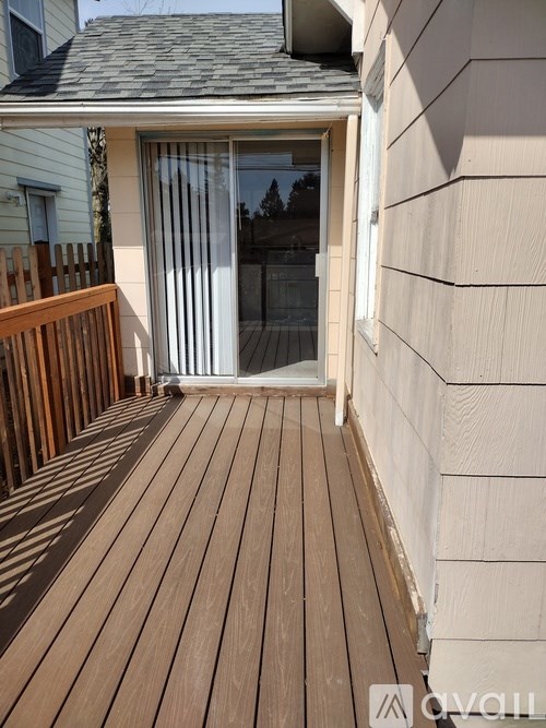 A wooden deck leads to a sliding glass door.
