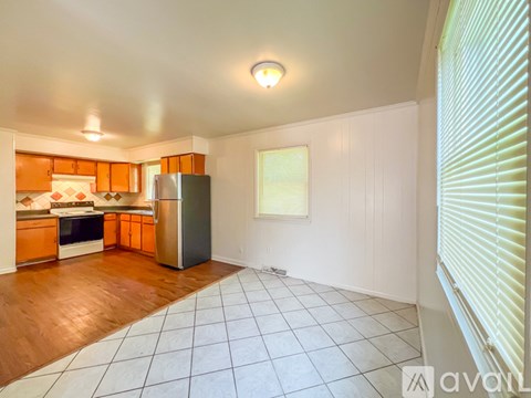 A kitchen with wooden floors and white walls.