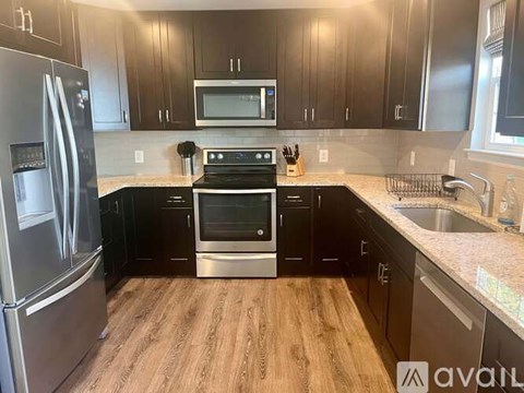 A kitchen with a refrigerator, oven, and microwave.