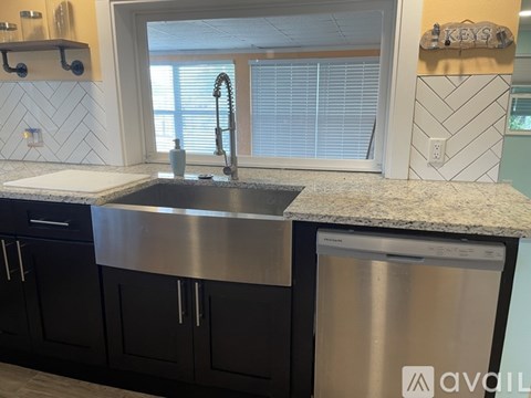 A kitchen with a sink and a window.