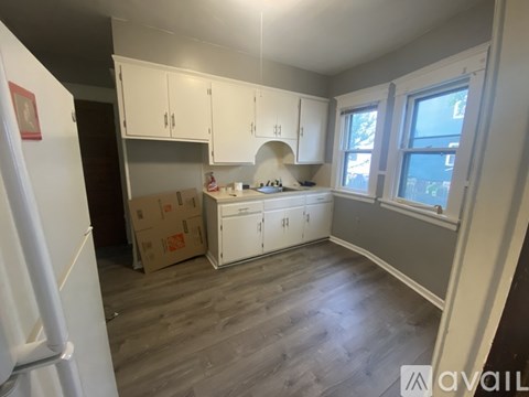 A kitchen with white cabinets and a refrigerator.