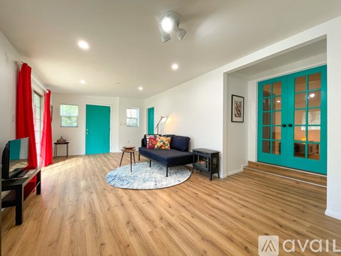 A living room with a blue couch and a rug.