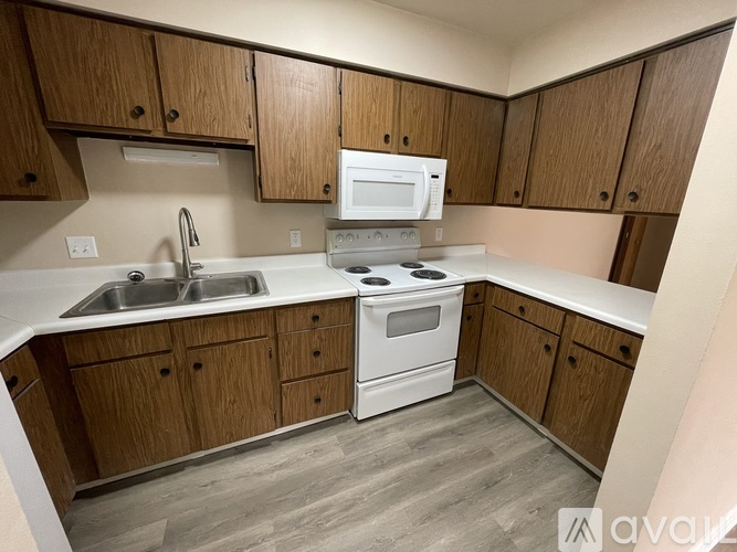 A kitchen with wooden cabinets and white appliances.