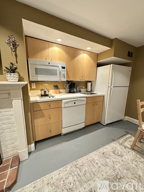 A kitchen with brown cabinets and a white refrigerator.