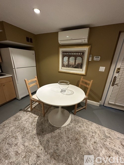 A dining room with a white table and chairs.