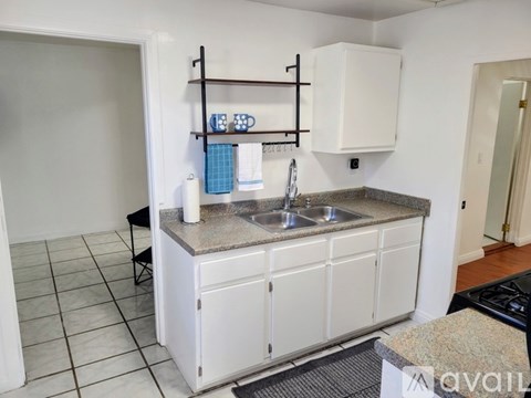 A kitchen with white cabinets and a granite countertop.