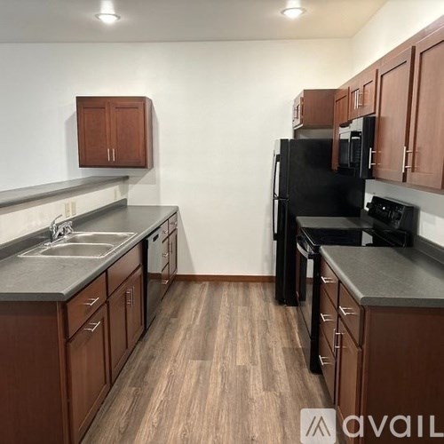 A kitchen with wooden cabinets and black appliances.